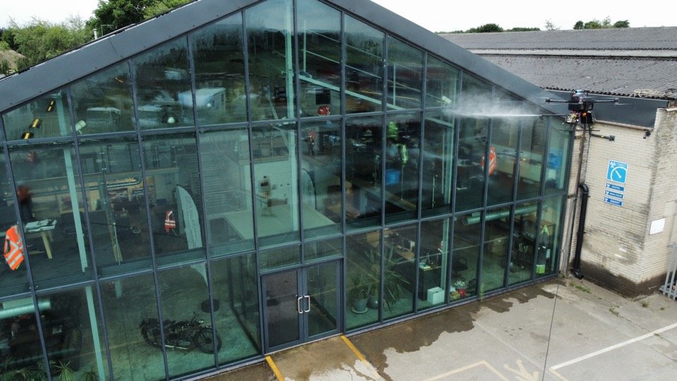 Drone cleaning a glazed commercial building