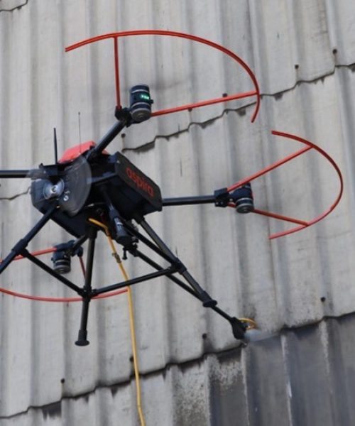 Commercial drone pressure washing exterior brick building
